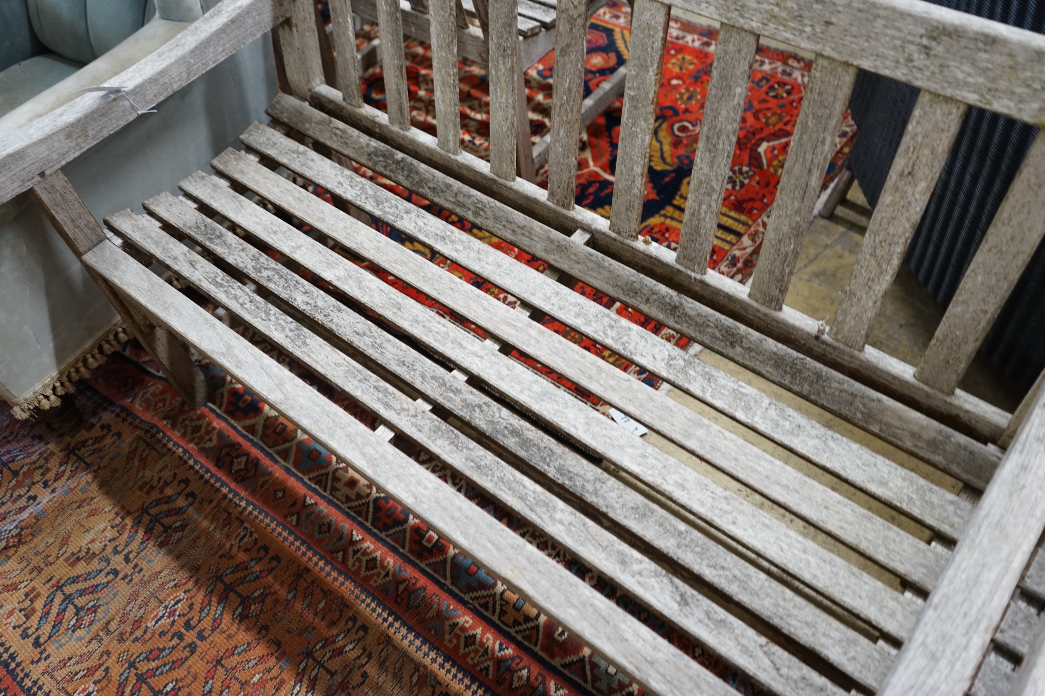 A pair of weathered teak slatted garden benches, each length 121cm, depth 56cm, height 85cm